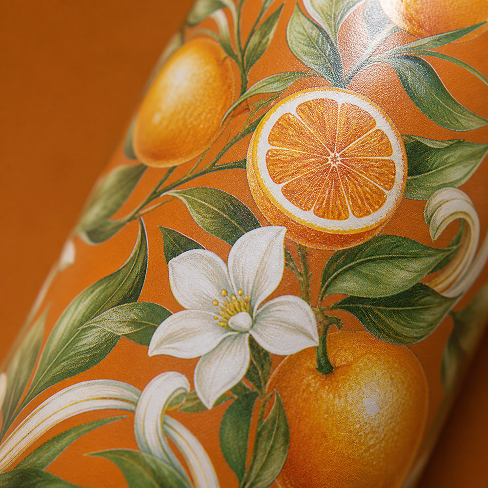 Close-up van het sinaasappel- en bloesemmotief op de IZY Thermosfles Fiore d'Arancia
