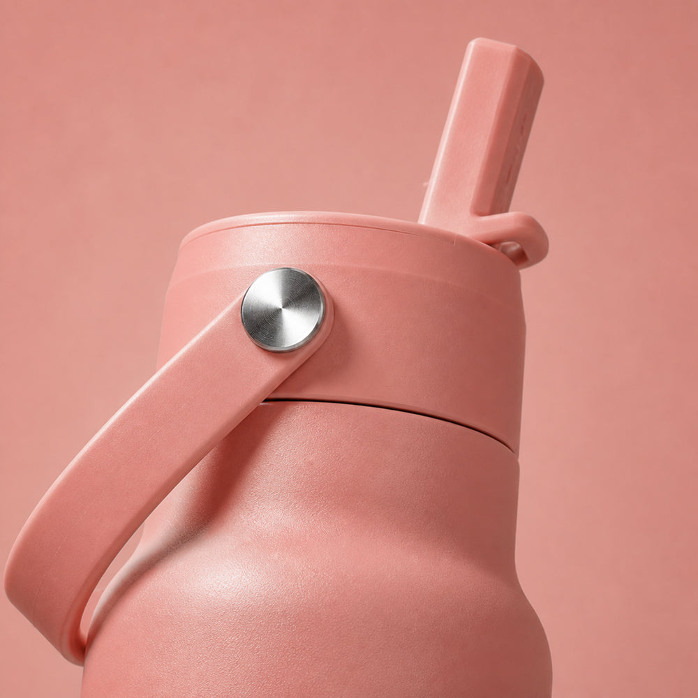 Close-up van de zalmroze dop met rietje van de IZY Travel Bottle