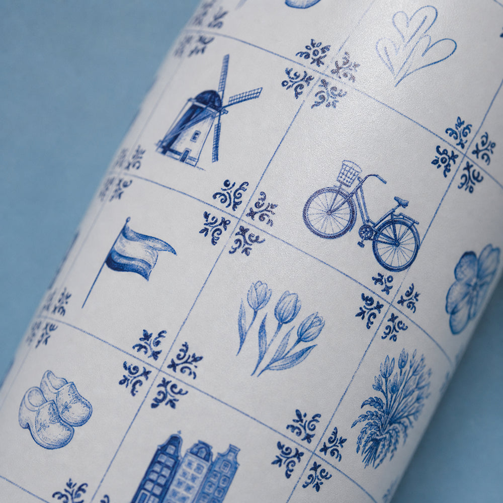 Close-up van het wit-blauwe tegelmotief met molen, fiets en tulp op de IZY Thermosfles