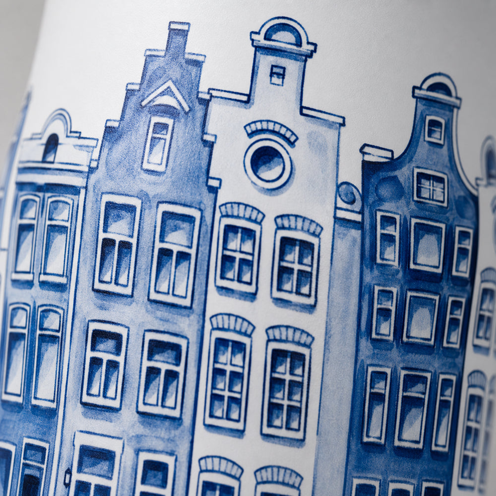 Close-up van het wit-blauwe grachtenpandenmotief op de IZY Travel Bottle