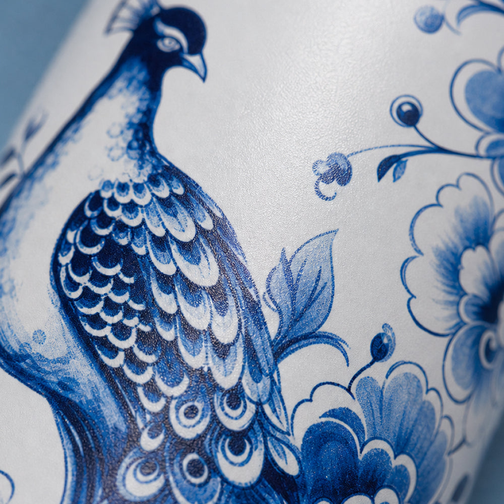 Close-up van het wit-blauwe pauwmotief met bloemen op de IZY Thermosbeker