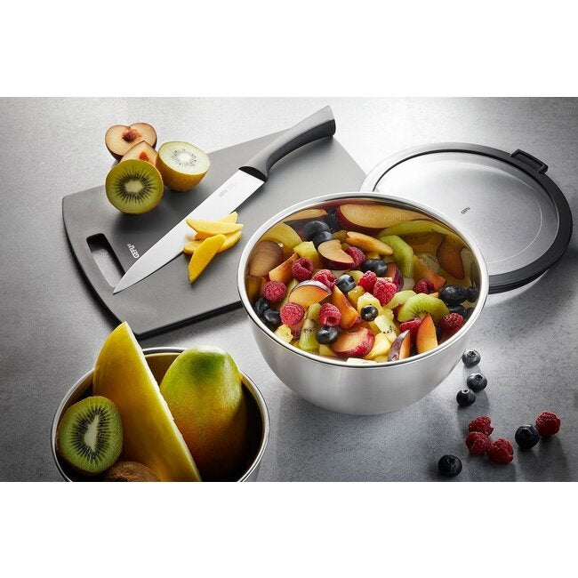 GEFU Kommenset Mondi - 3-delig, de kleinste kom met deksel gevuld met gesneden kiwi, mango en bosbessen naast een snijplank met mes en fruit