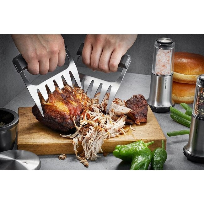 GEFU Vleesklauwen - 2 stuks, twee handen die met de klauwen gepulled pork uit elkaar trekken op een houten plank, met broodjes en kruiden ernaast