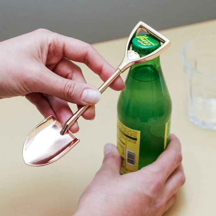 Kikkerland Flesopener Koperen Schep, sfeerbeeld, een hand opent er een flesje bier mee