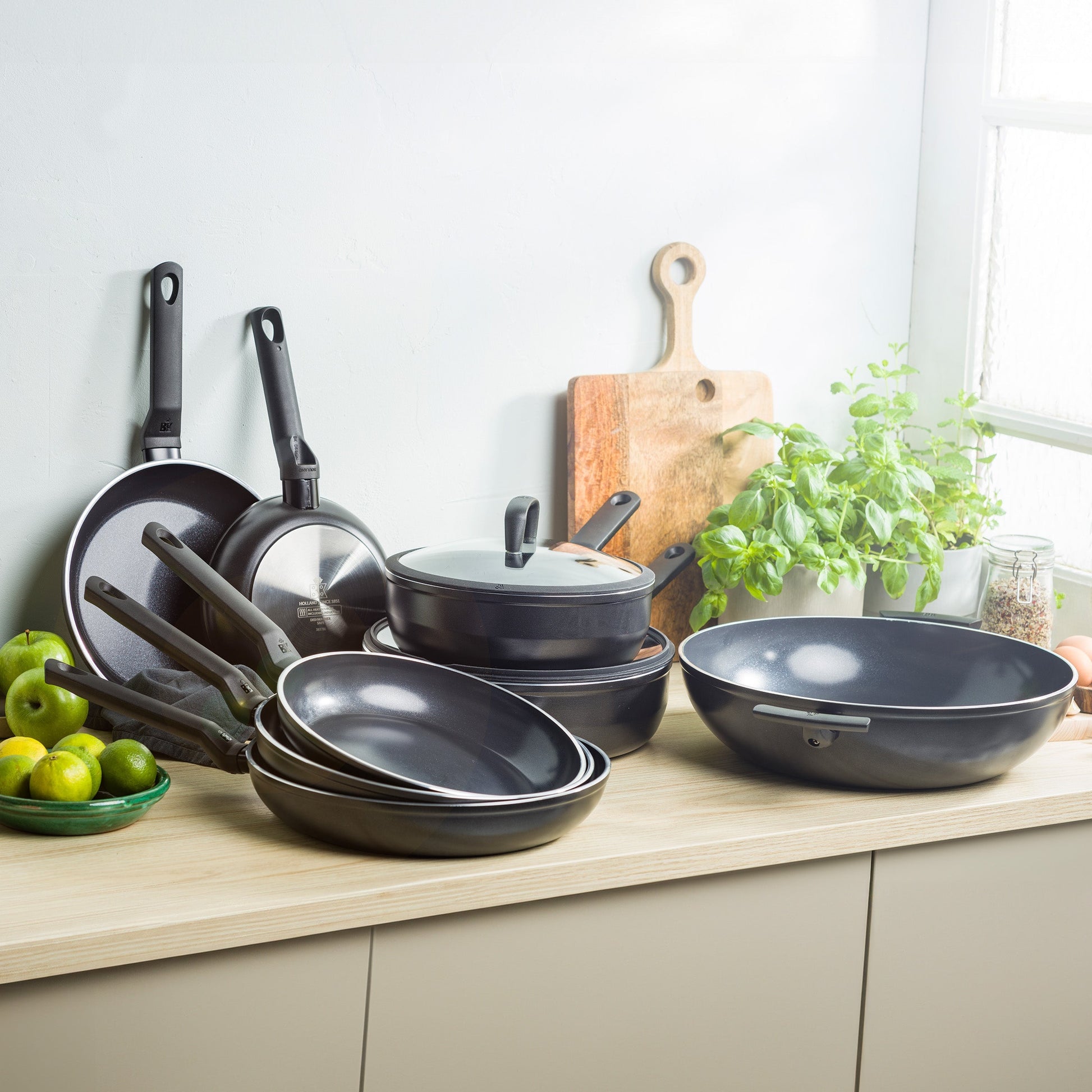 Set zwarte BK Easy Induction pannen en wadjan op een aanrecht bij een raam.