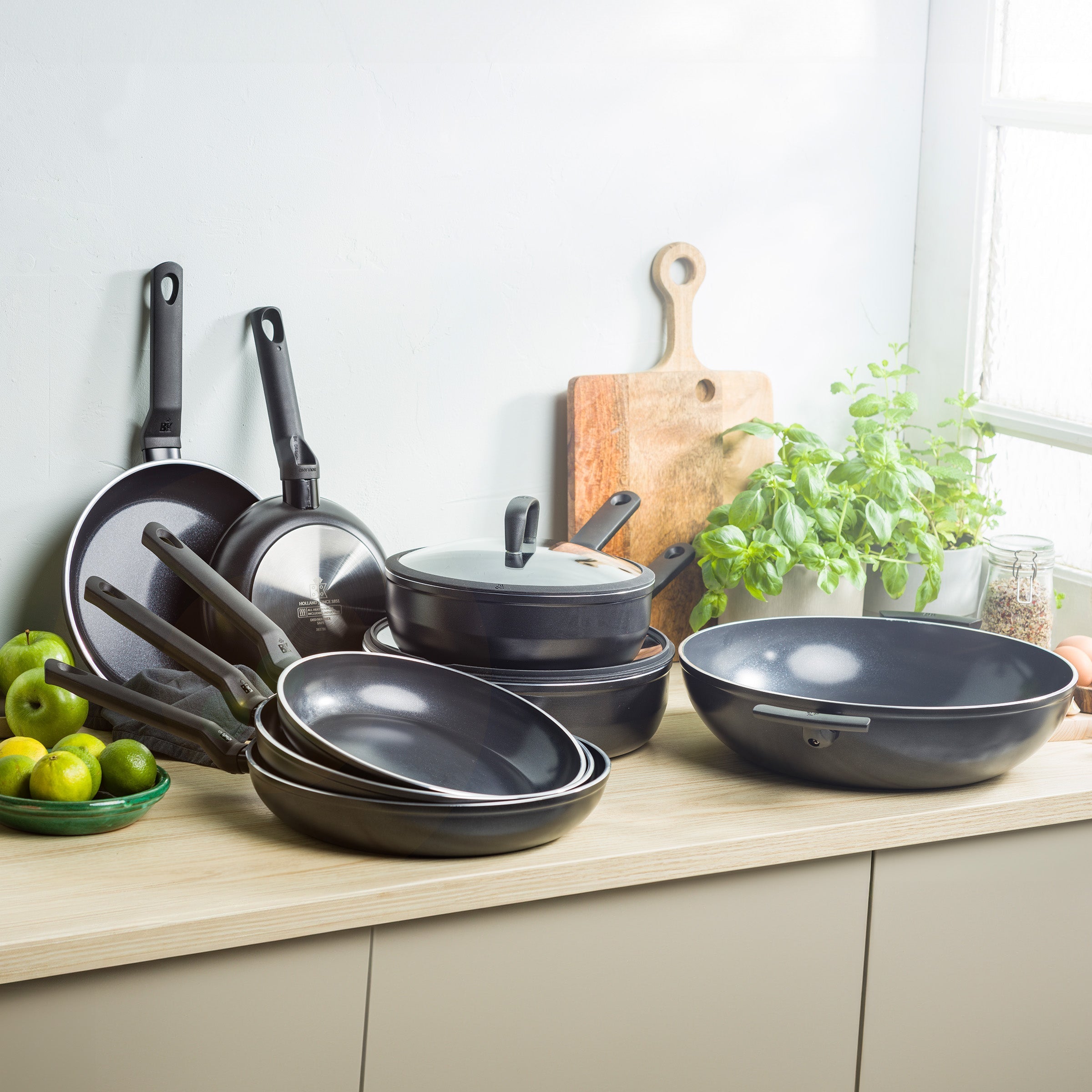 Set zwarte BK Easy Induction pannen en wadjan op een aanrecht bij een raam.