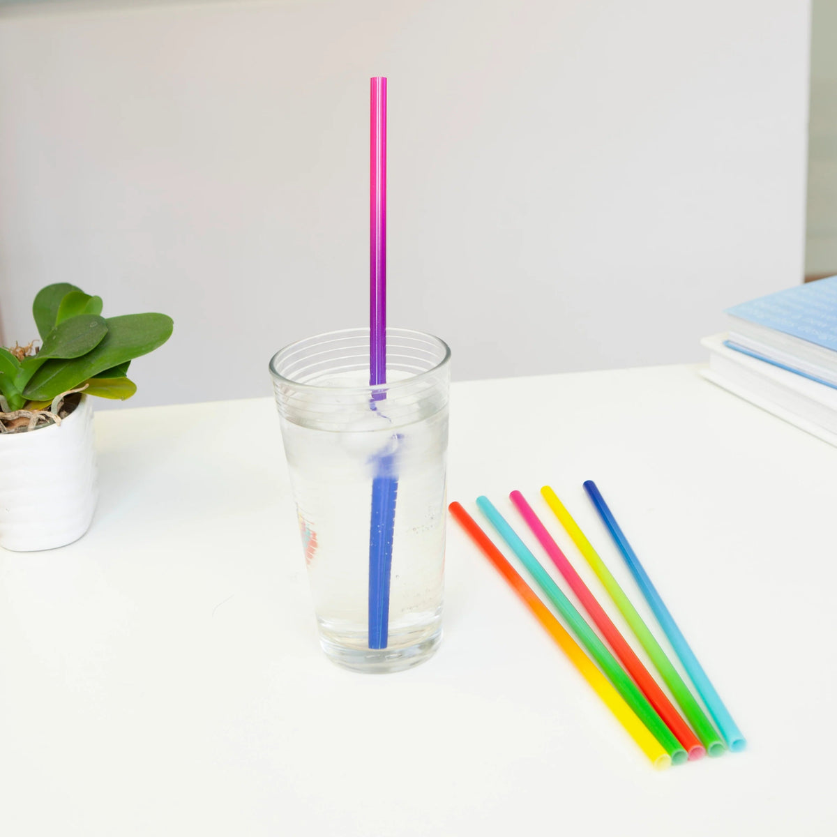 Kikkerland Rietjes Herbruikbaar Kunststof - 12 stuks, sfeerbeeld, de rietjes in een glas op een bureau