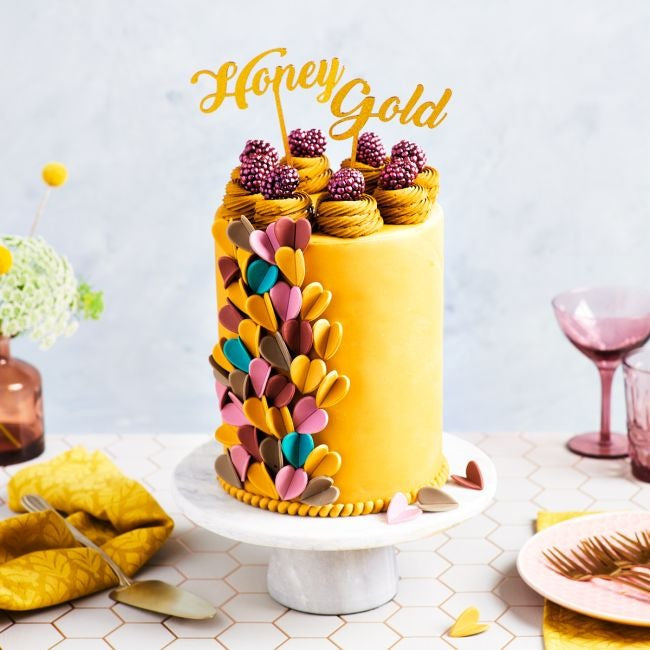 Taart met 'Honey Gold' topper, goudkleurig glazuur, bramen en chocoladebladeren