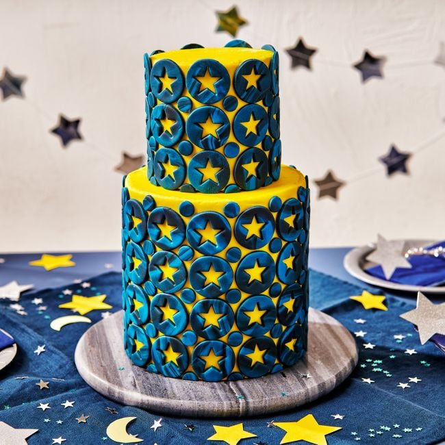 Tweelaagse taart met blauwe cirkels en gele sterren decoratie