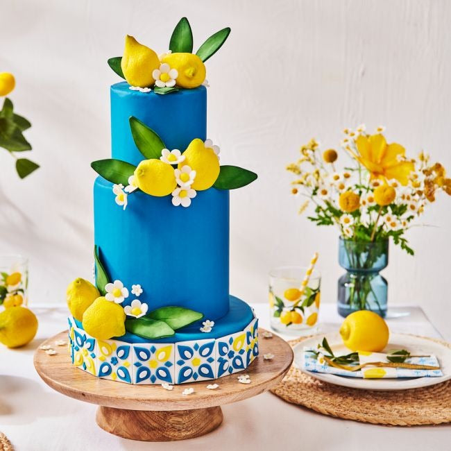 Blauwe taart met suikercitroenen, bladeren en witte bloemen