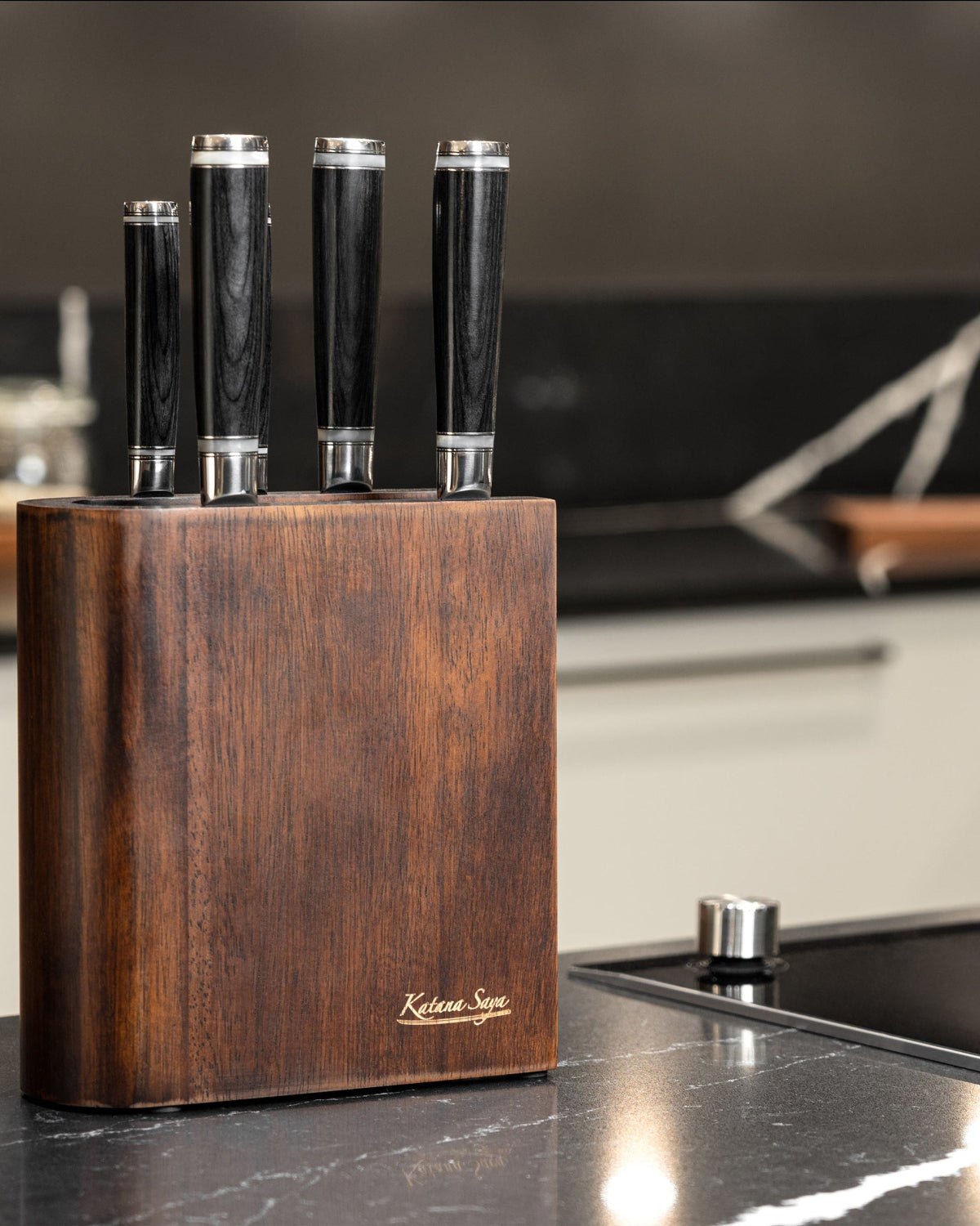 Donkerbruin messenblok met vier messen op een zwart aanrechtblad in een moderne keuken
