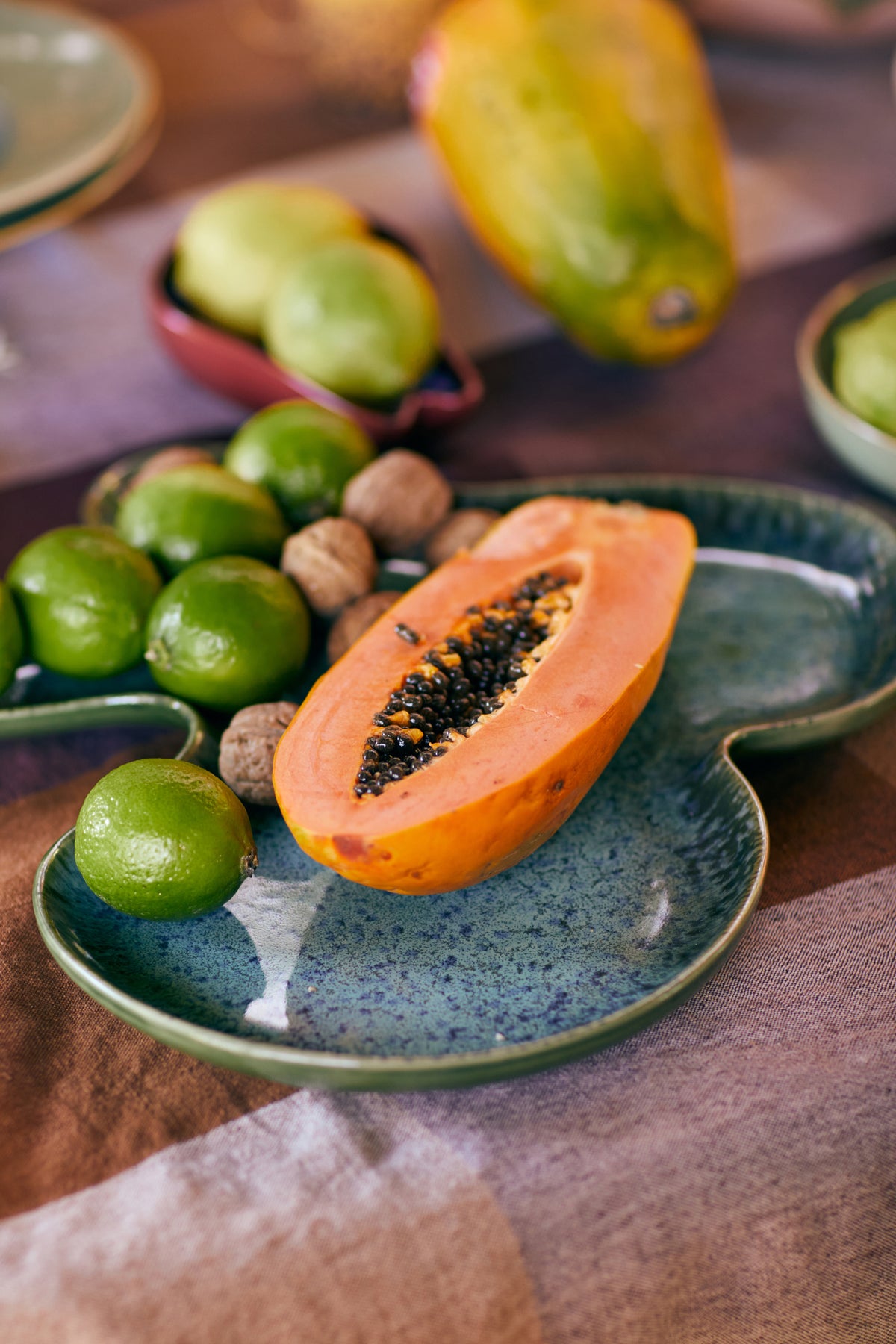 HKLiving Shell Bord Teal gedekt met papaya, limoen en kastanjes