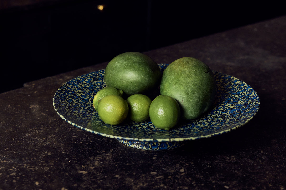 HKLiving 70's Fruitschaal plat Noise gevuld met limoenen tegen een donkere achtergrond