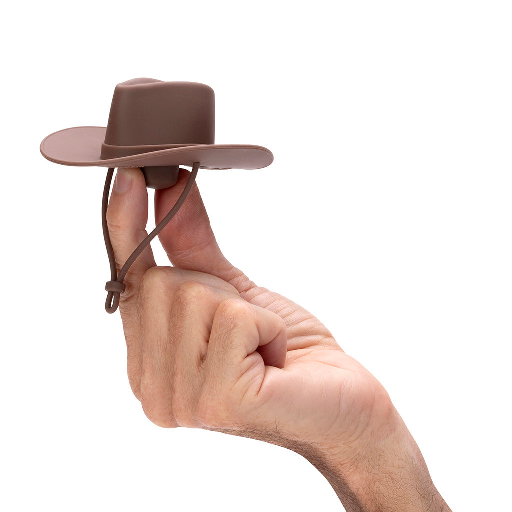 Een hand houdt de bruine cowboyhoed-stopper vast op een vingertop