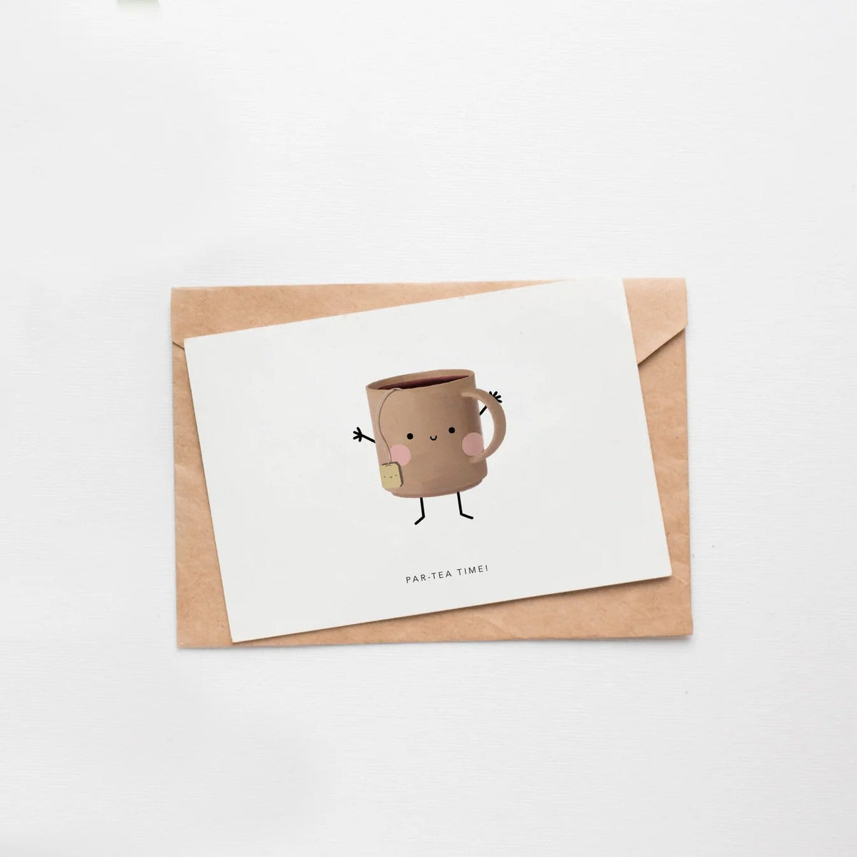 Wenskaart van Depre Design met een geïllustreerde theemok, liggend op een witte ondergrond met de envelop erachter.