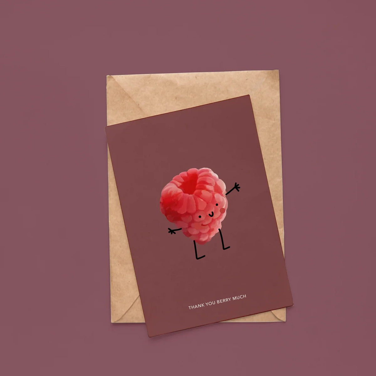 Wenskaart van Depre Design met een geïllustreerde framboos en de tekst 'Thank you berry much', op een kraft envelop tegen een donkerrode achtergrond.