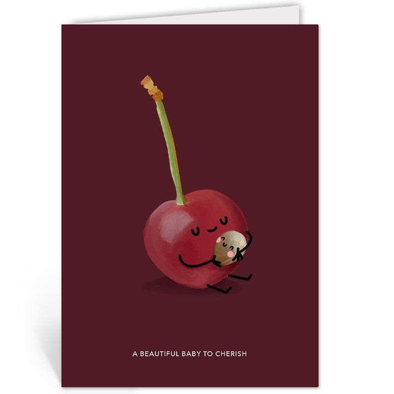 Bordeauxrode geboortekaart met kersen-illustratie, liggend op een kraftpapieren envelop.