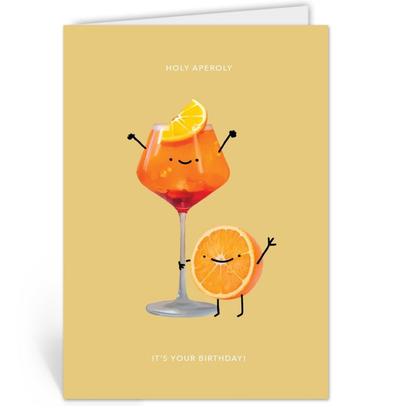 Opengevouwen wenskaart 'Holy Aperoly, It's Your Birthday' van Depre Design met het Aperol-glas en sinaasappelschijfje, witte envelop op de achtergrond.