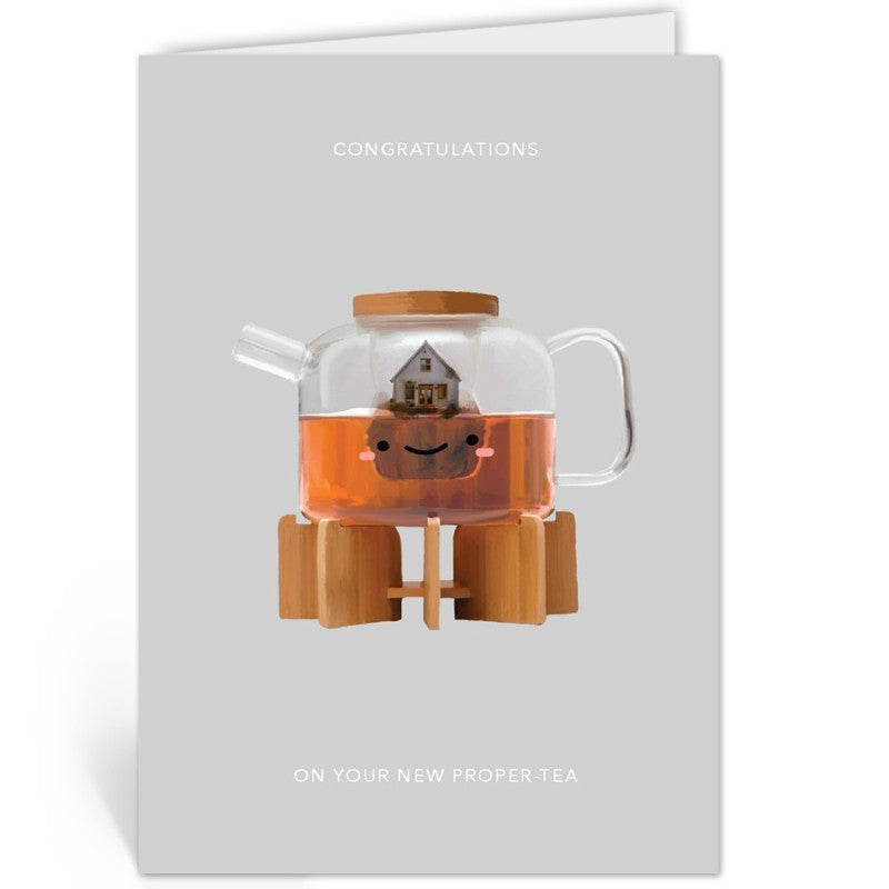 Wenskaart met theepot-illustratie liggend op een kraft envelop tegen grijze achtergrond