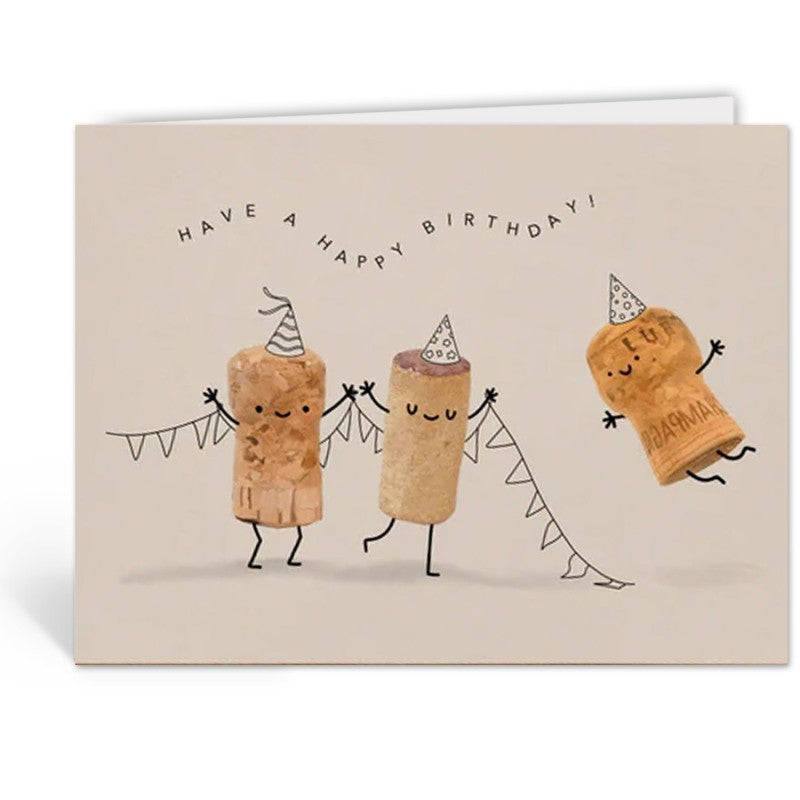 Opengeslagen wenskaart met drie kurkfiguurtjes en de tekst 'Have a happy birthday!', envelop op de achtergrond.
