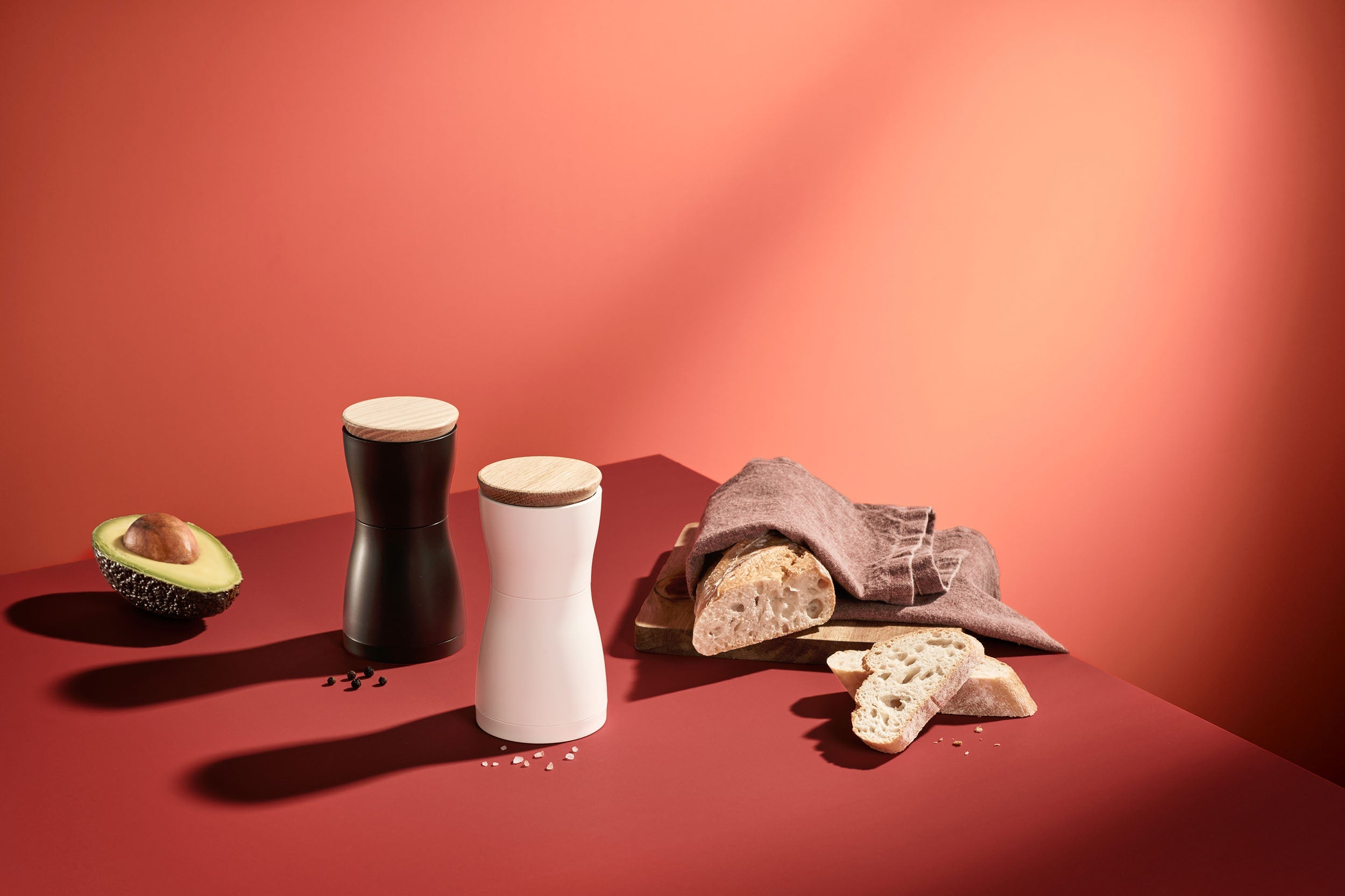 AdHoc Twin molens in zwart en wit met houten deksel op een terracotta tafel bij brood en avocado