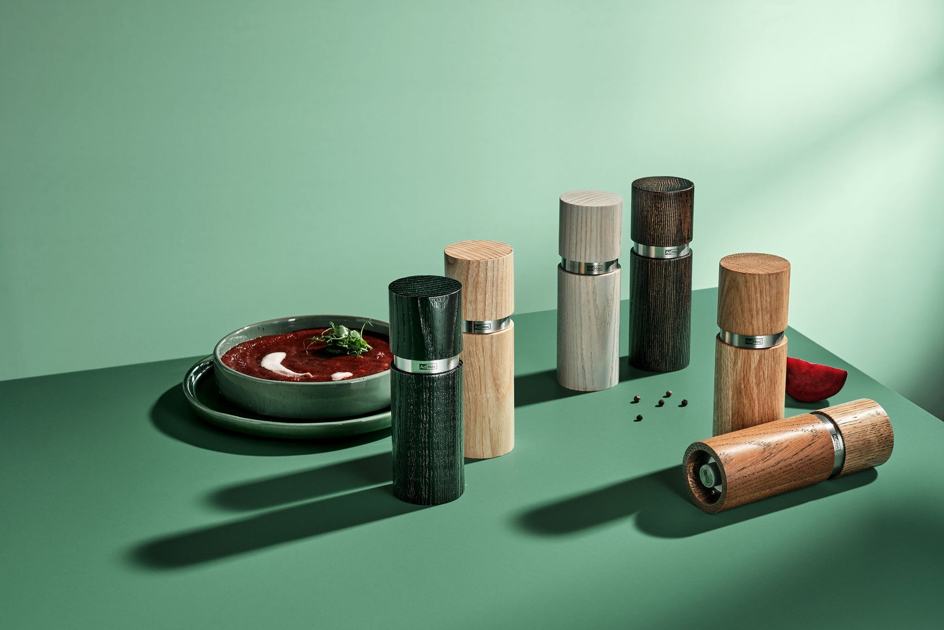 AdHoc Textura molens in diverse houttinten op een groene tafel bij een bord tomatensoep