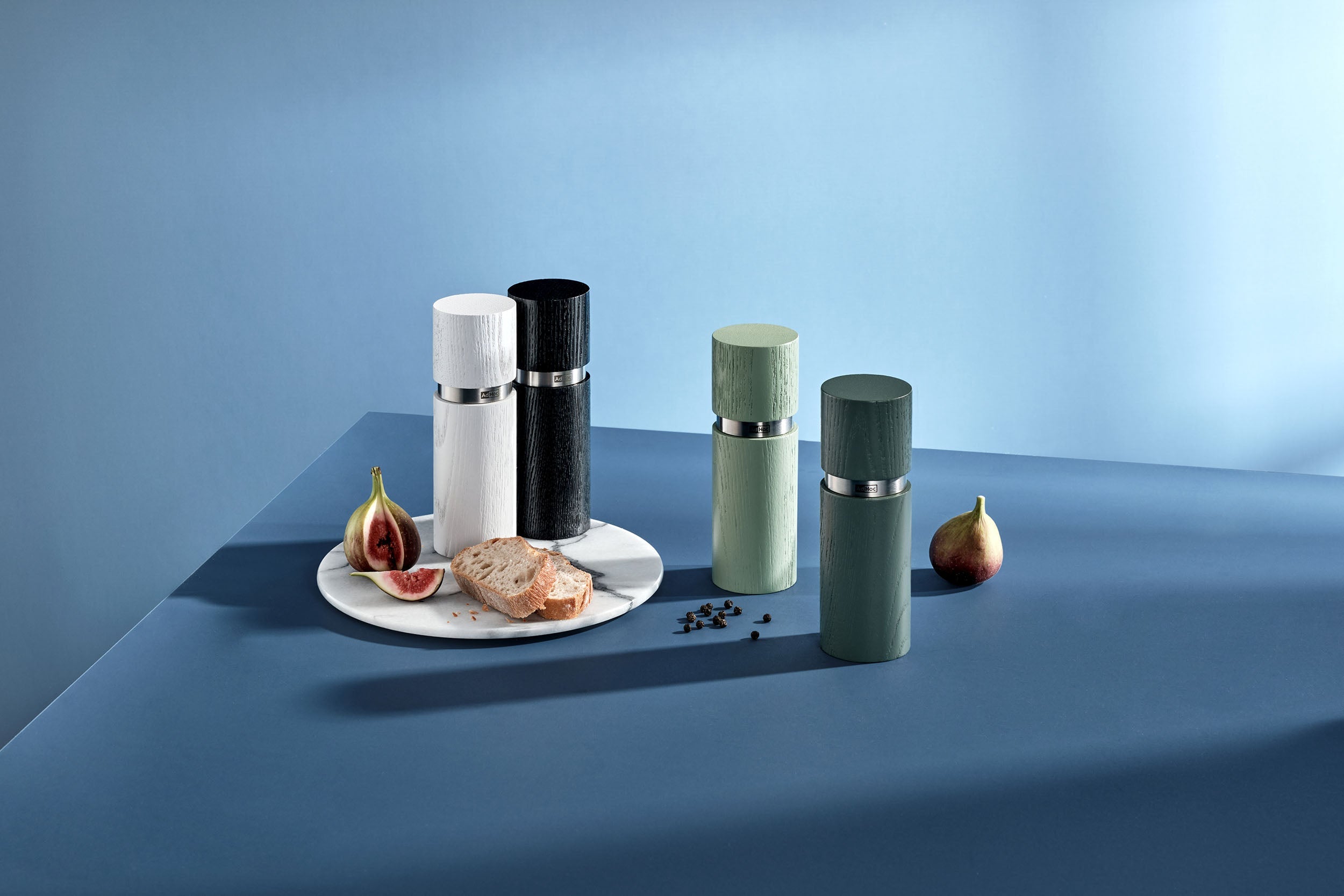 AdHoc Textura molens in wit, zwart en twee groentinten op een blauwe tafel met vijgen en brood