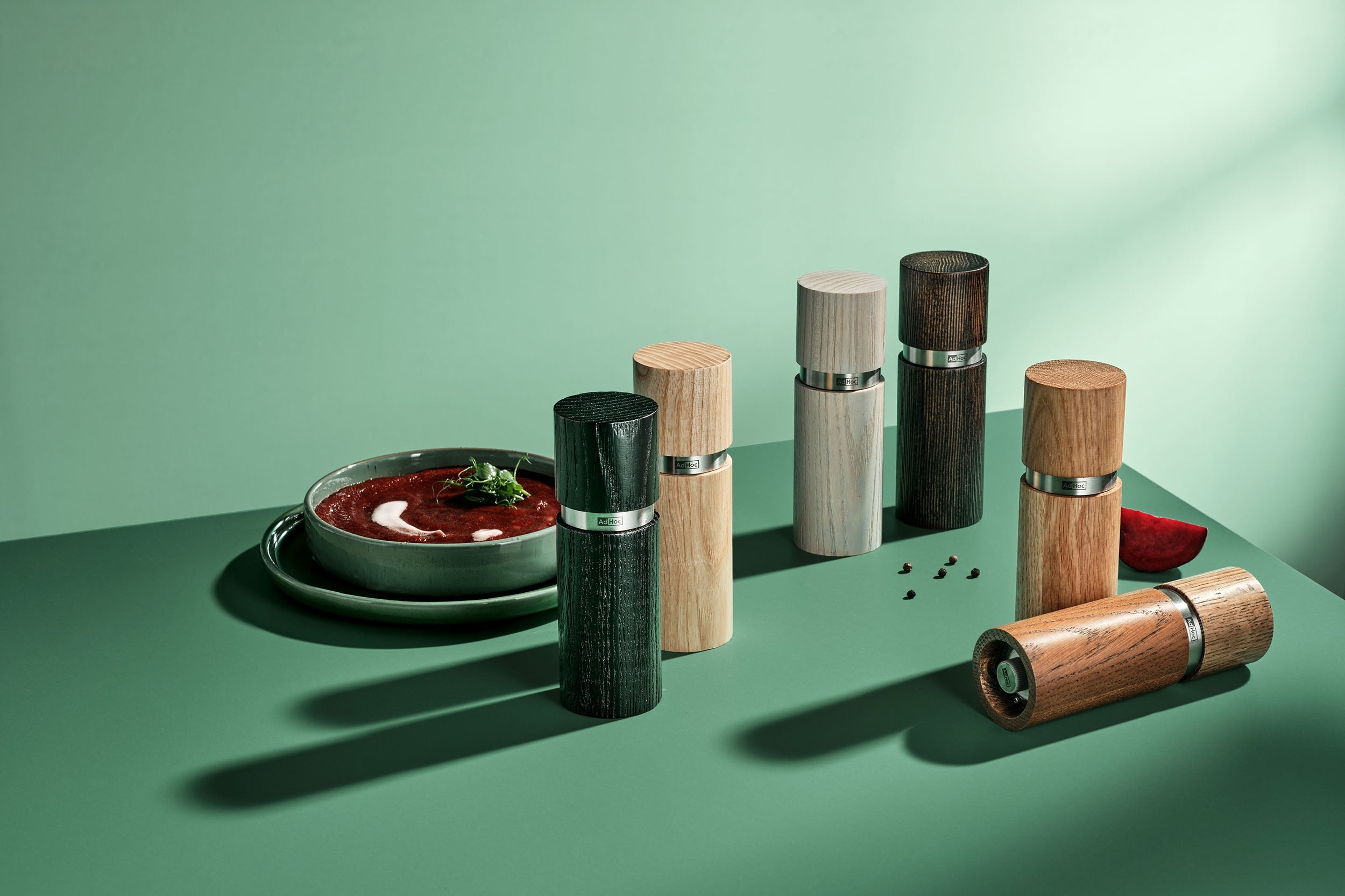 AdHoc Textura molens in diverse houttinten op een groene tafel bij een bord tomatensoep