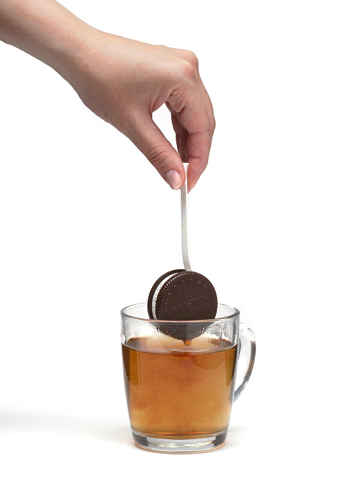 Hand die de CookieTea theefilter in een mok thee laat zakken