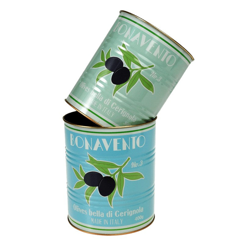 Het mintgroene blik schuin over de rand van het lichtblauwe blik gelegd, met op beide de opdruk van een olijventak