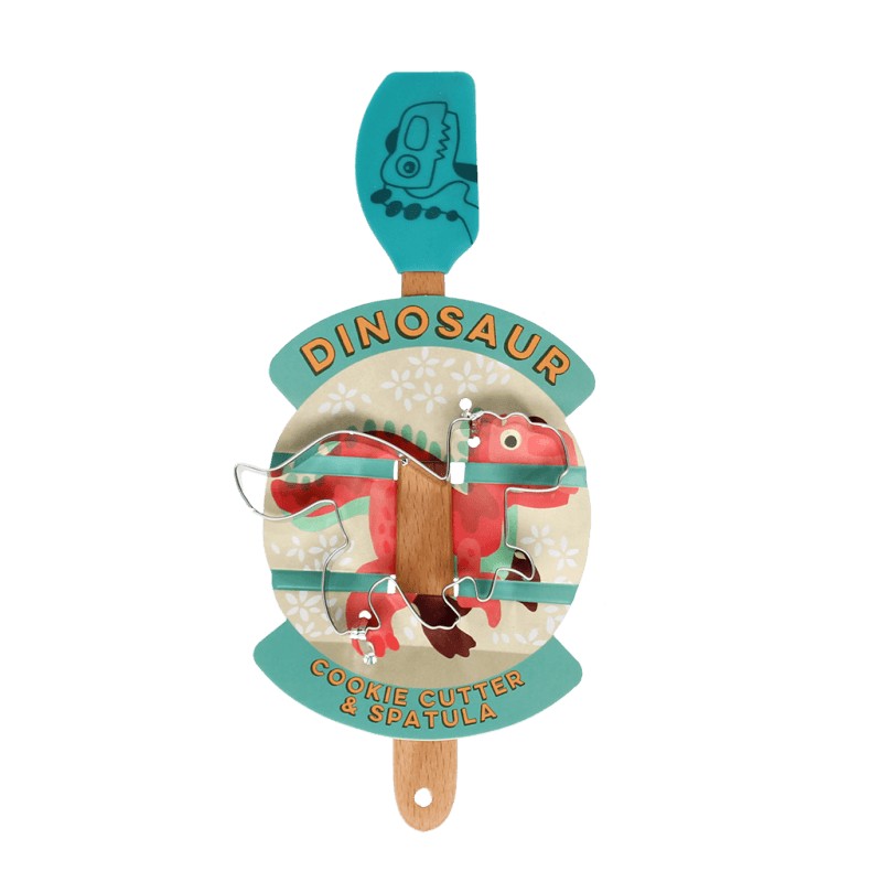 Roestvrijstalen dinosaurus-uitsteekvorm en turquoise spatel met houten handvat op de verpakkingskaart met een rode dinosaurus en de tekst Dinosaur Cookie Cutter & Spatula
