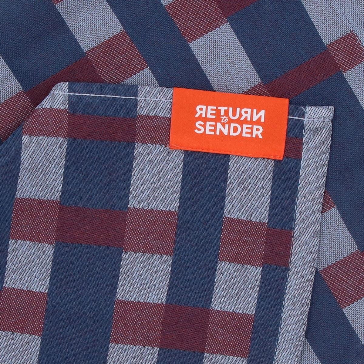 Theedoek Geometric Sofia - Blue, close-up van oranje label en blauw met bordeauxrode ruit bij de omgeslagen hoek