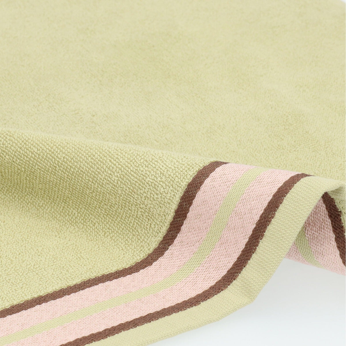 Keukendoek Ana - Sage Green, close-up van saliegroene badstof en de roze streepband met bruine randen
