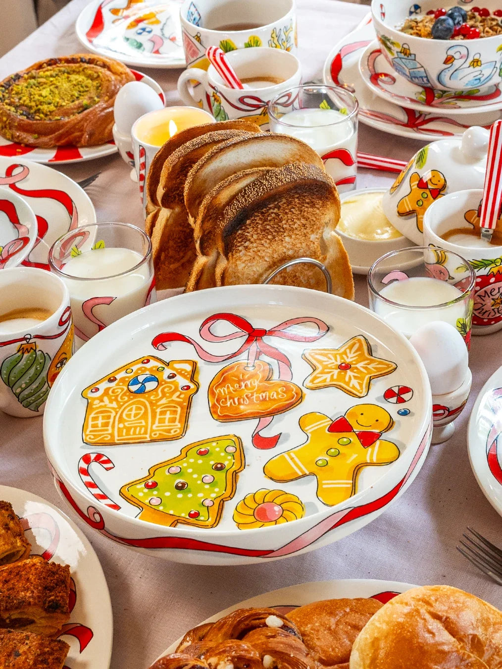 Het taartplateau met peperkoekkoekjes op een gedekte ontbijttafel naast brood en kopjes