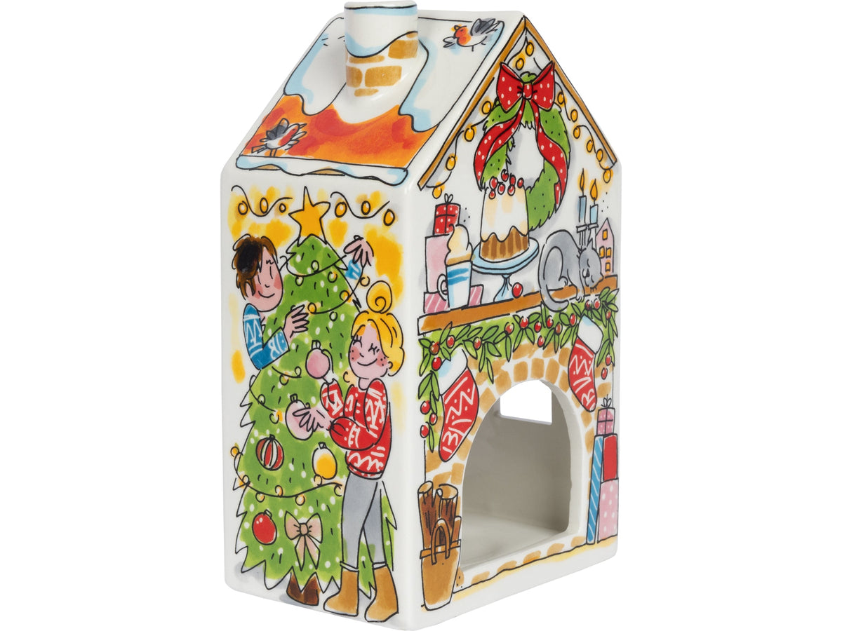 Het lichthuisje van opzij met een kerstboom en twee mensen die de boom versieren