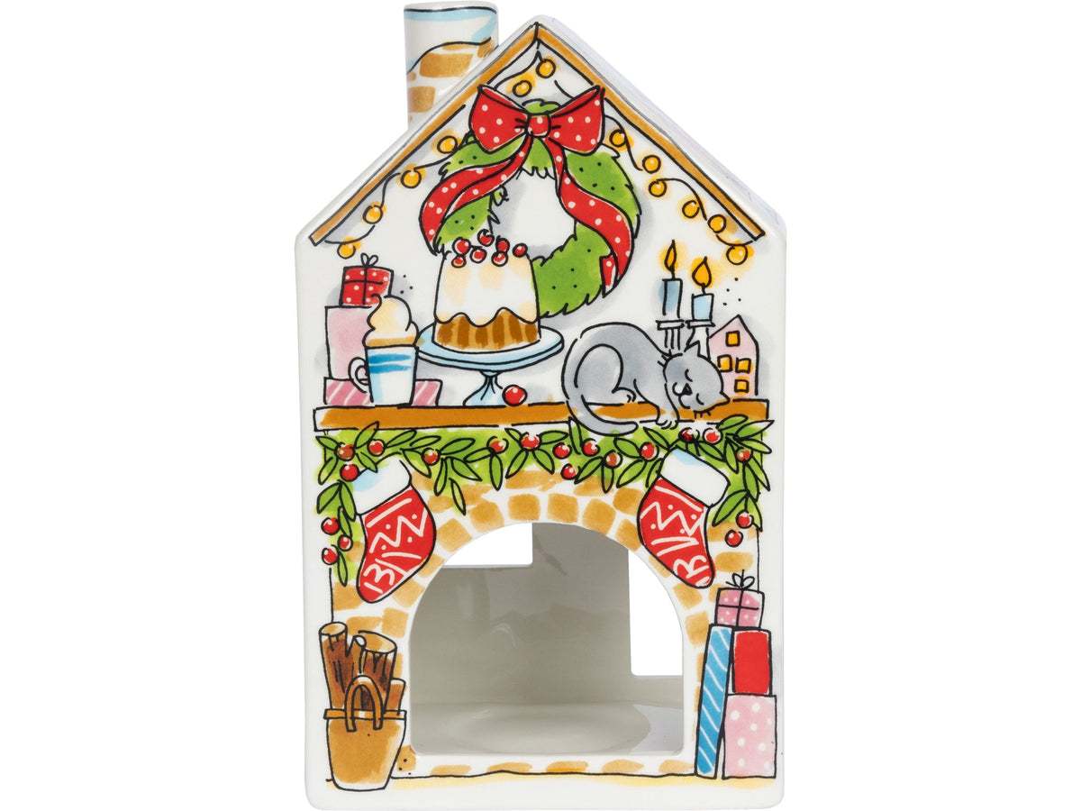 Achterkant van het lichthuisje met een krans, een haard met sokken en een grijze kat