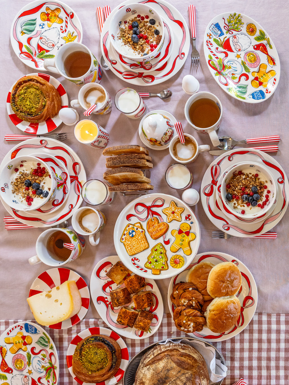 Ontbijttafel van bovenaf met kerstborden en kopjes met rode strepen