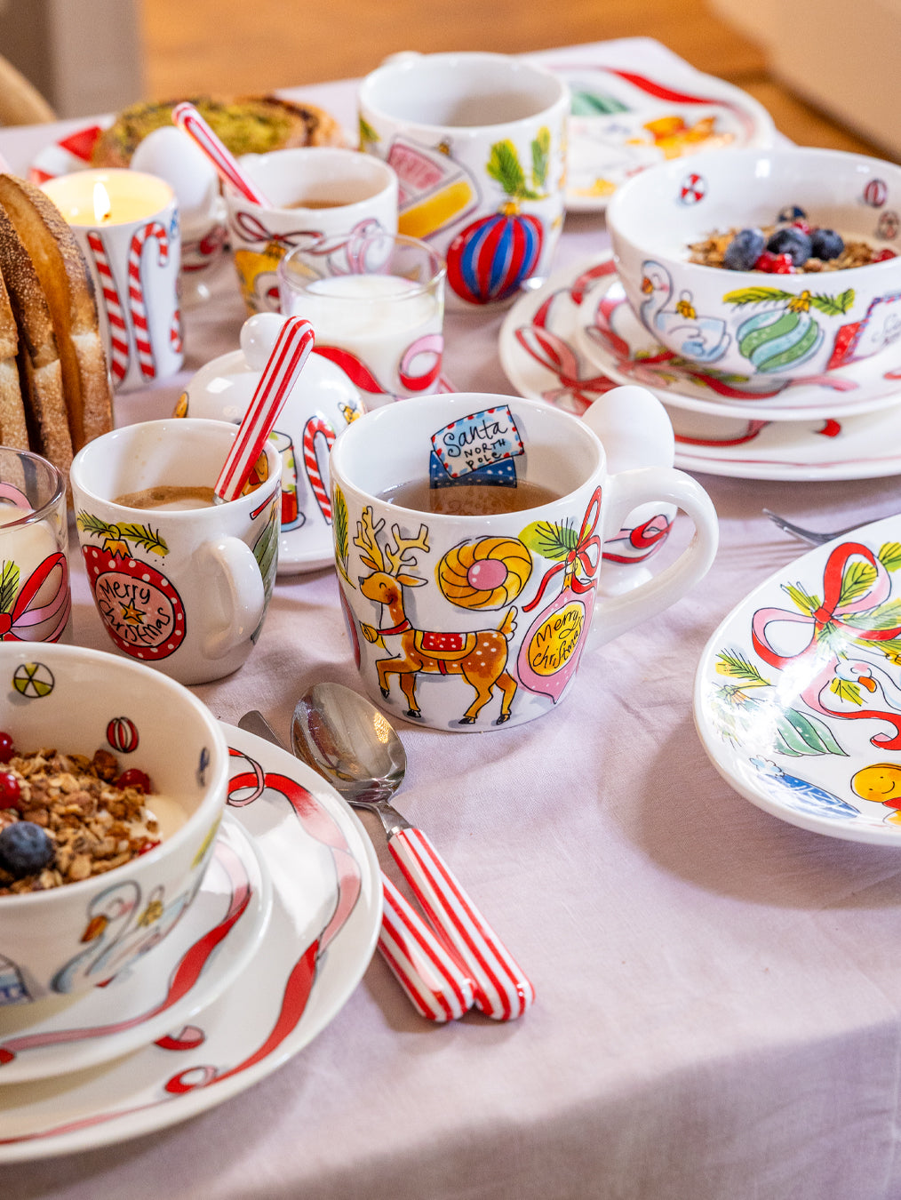 Ontbijttafel met minimokken met kerstballen naast kommen en borden