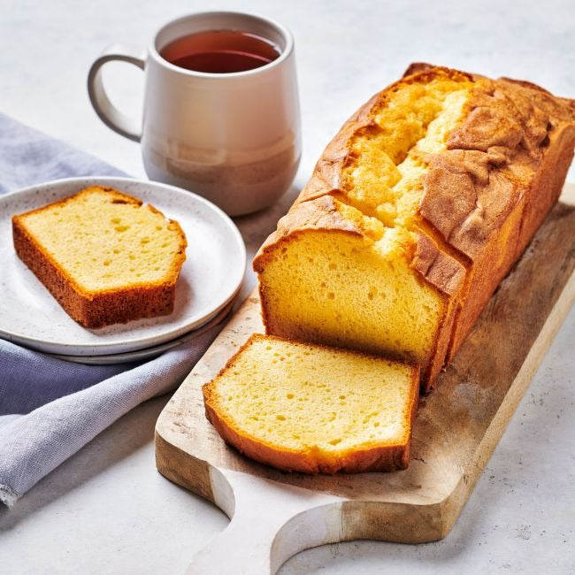 Plakken cake op een bord en snijplank naast een kop thee