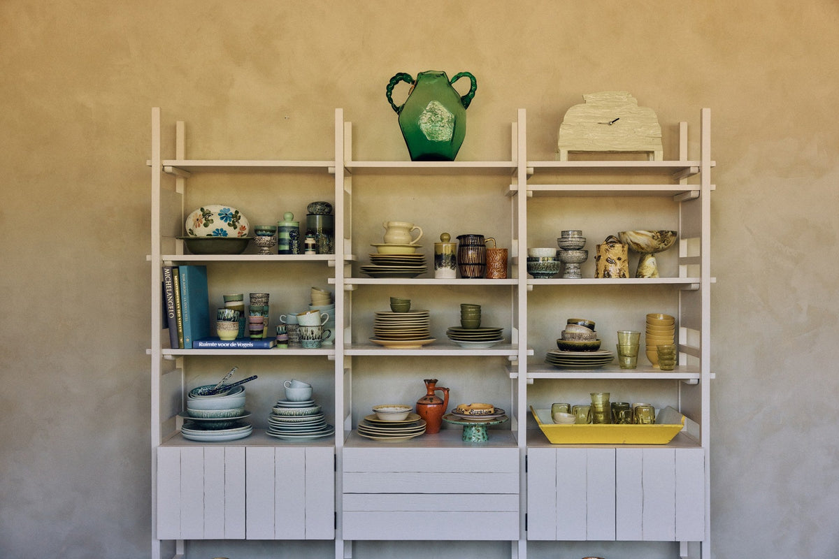 Open stellingkast met servies en glaswerk van HKLiving voor een warme muur