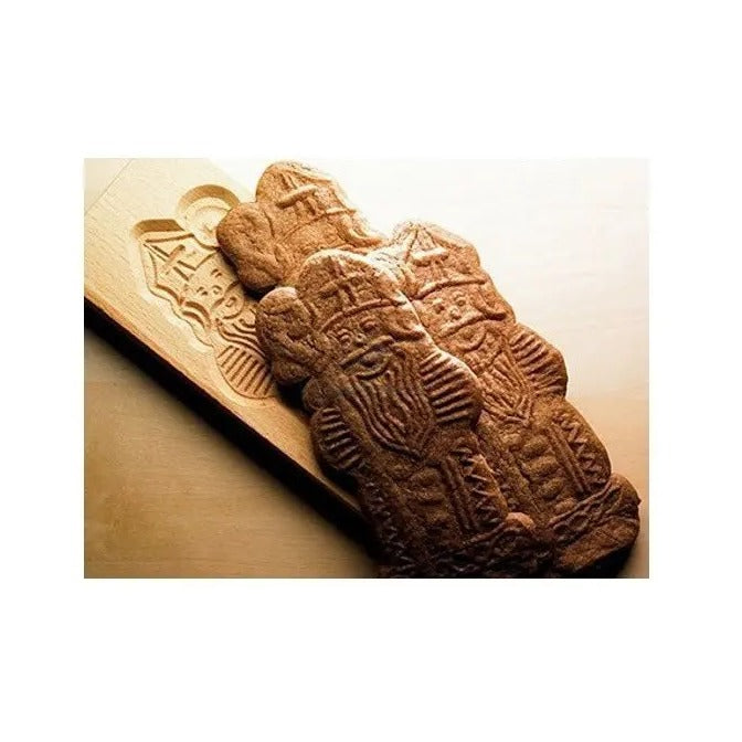 Gebakken speculaaspoppen liggen op een houten plank