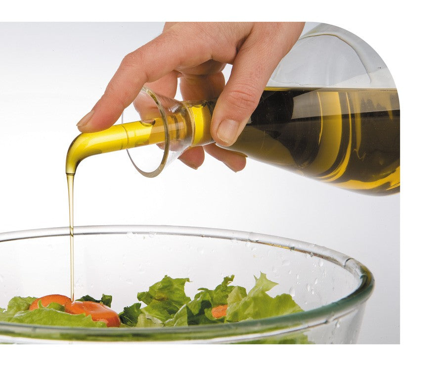 Ibili Glazen Oliekan, in gebruik tijdens het schenken van olijfolie over een salade.