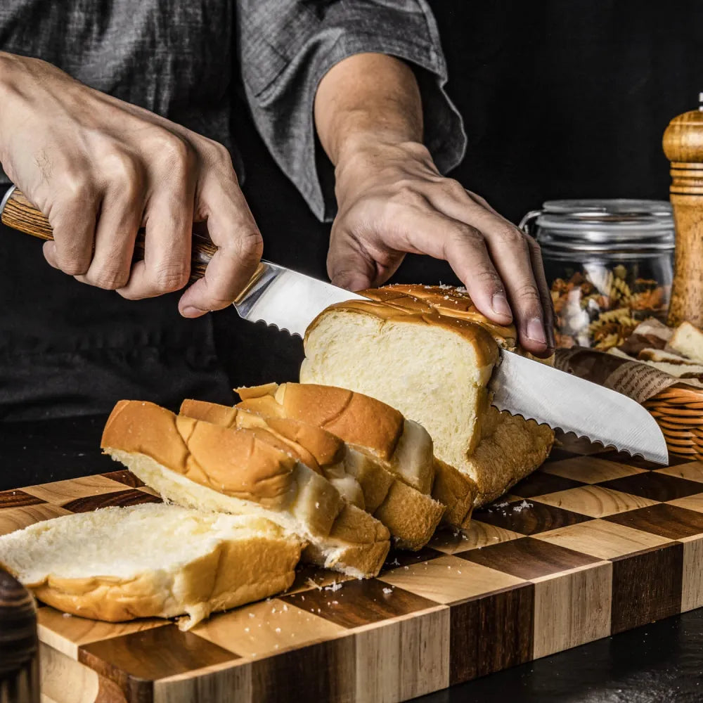 Handen snijden met het Kazoku Nisei broodmes een brood in plakken op een houten snijplank met ruitpatroon