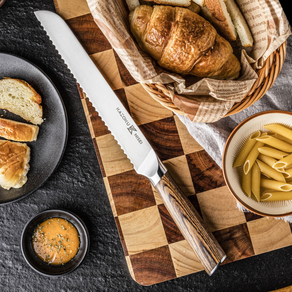 Kazoku Nisei broodmes op een snijplank met ruitpatroon naast croissants, brood en penne