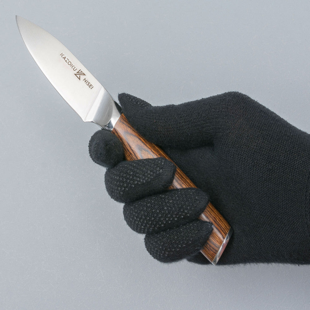 Hand met zwarte handschoen houdt het Kazoku Nisei officemes vast