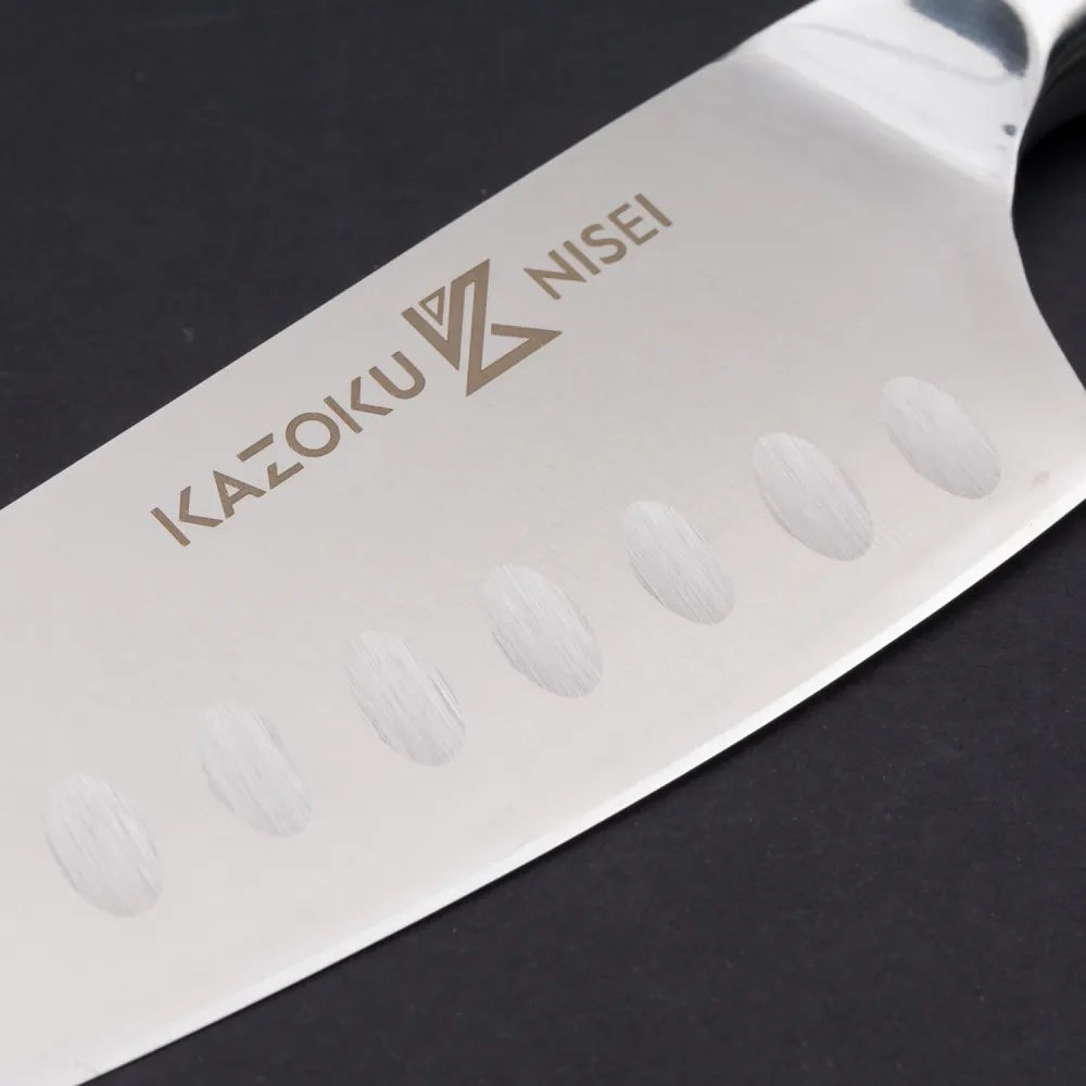 Close-up van het lemmet met kuiltjes en het Kazoku Nisei-logo van de santoku