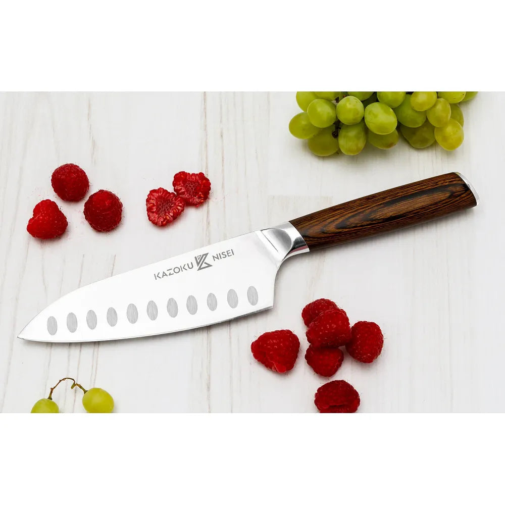 Kazoku Nisei santoku tussen frambozen en druiven op een witte houten ondergrond