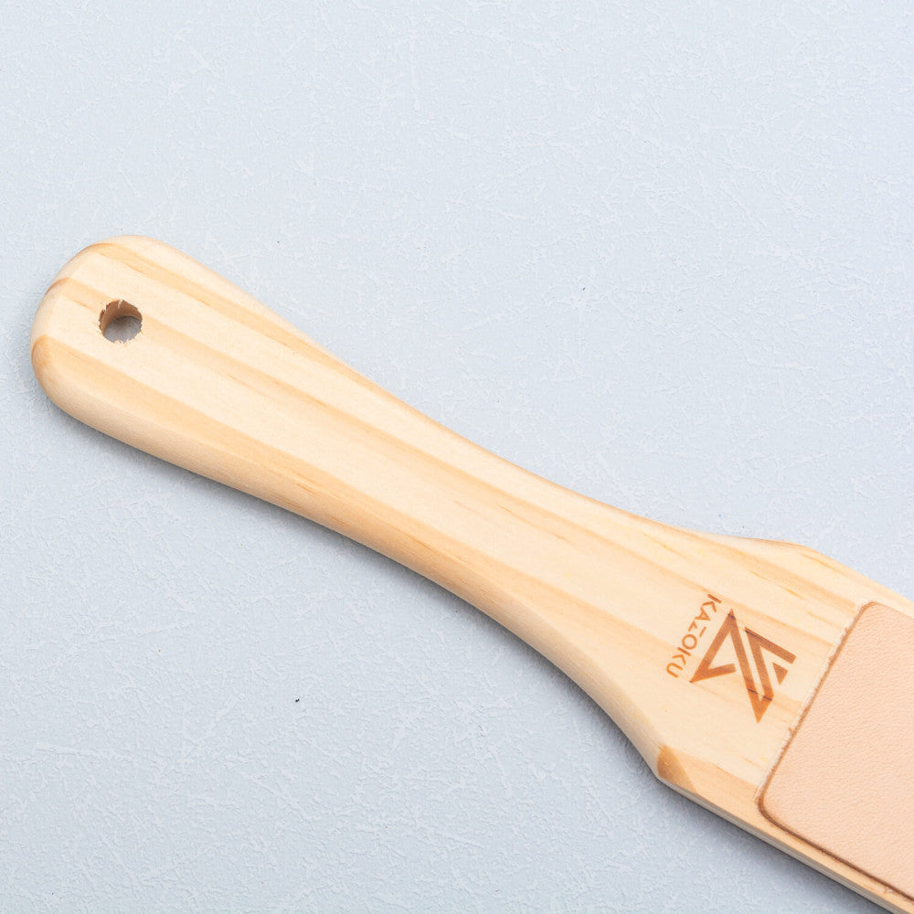 Close-up van de houten greep met ophangoog van de Kazoku paddle strop