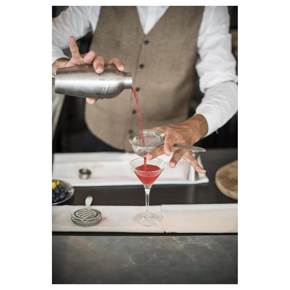De Leopold Vienna cocktailshaker op een gedekte tafel met glazen en limoen