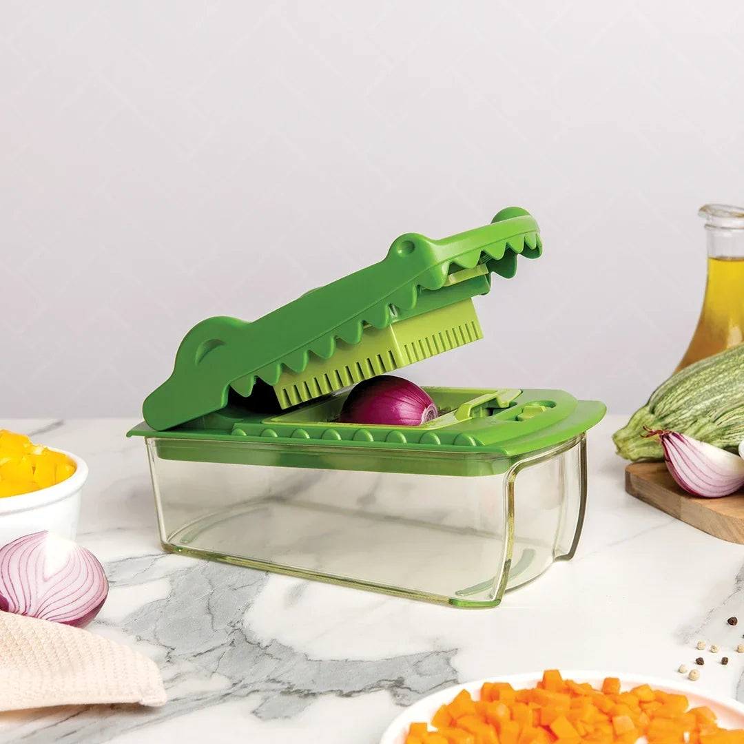 Groene krokodillensnijder met rode ui en groente op een marmeren aanrecht